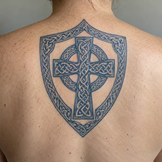 Woad blue Celtic cross tattoo on the upper back