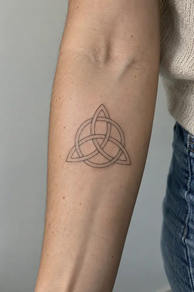 Fine-line trinity knot tattoo on the forearm